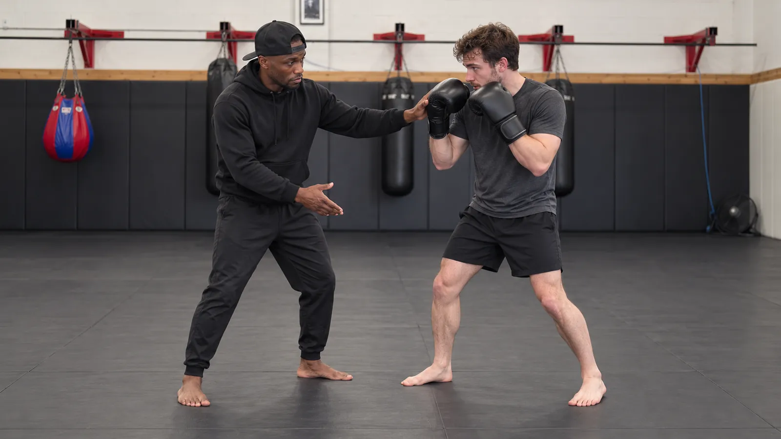 A boxing coach adjusts a student's guard and stance