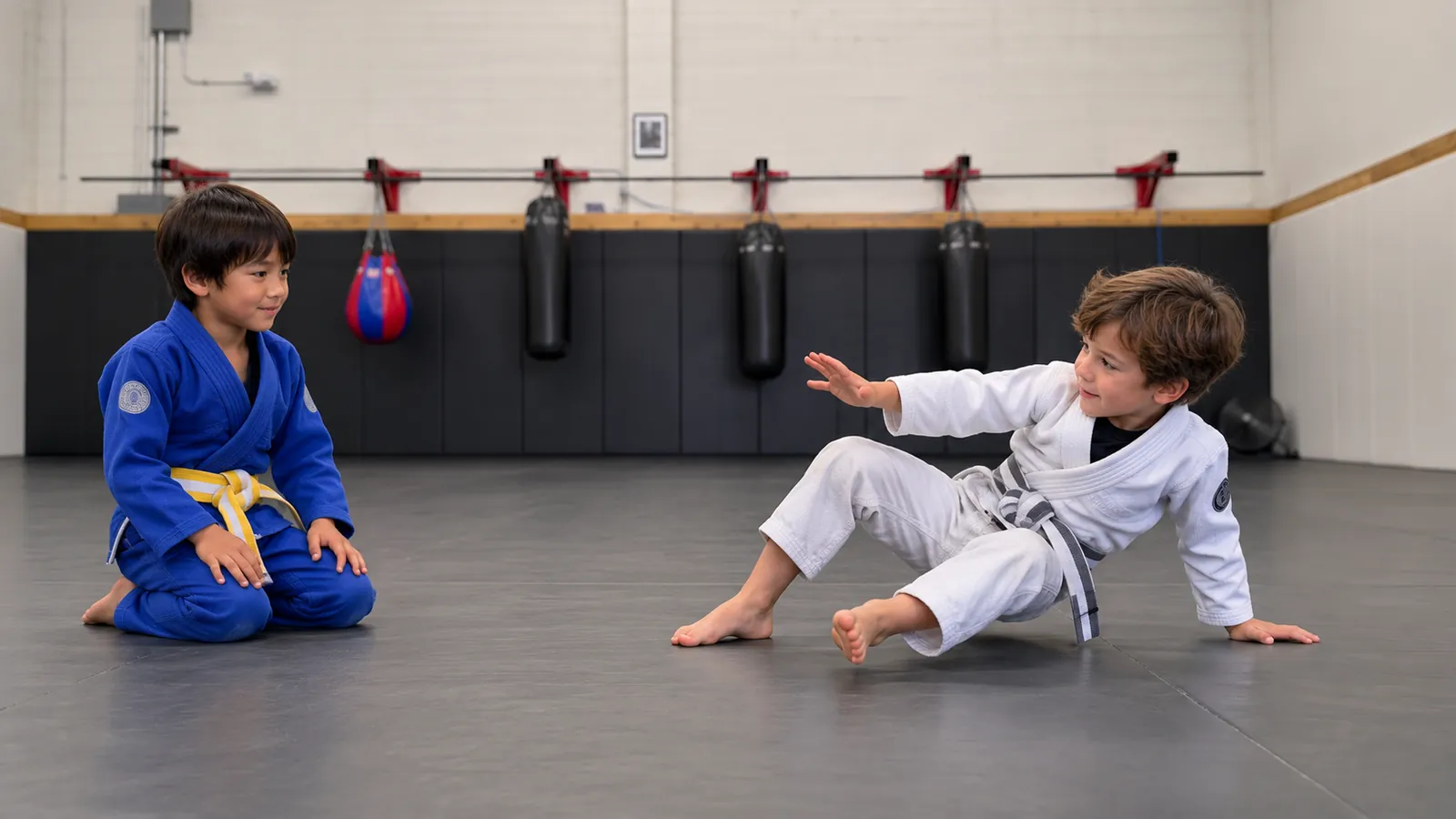 A child practises getting up safely while a training partner watches