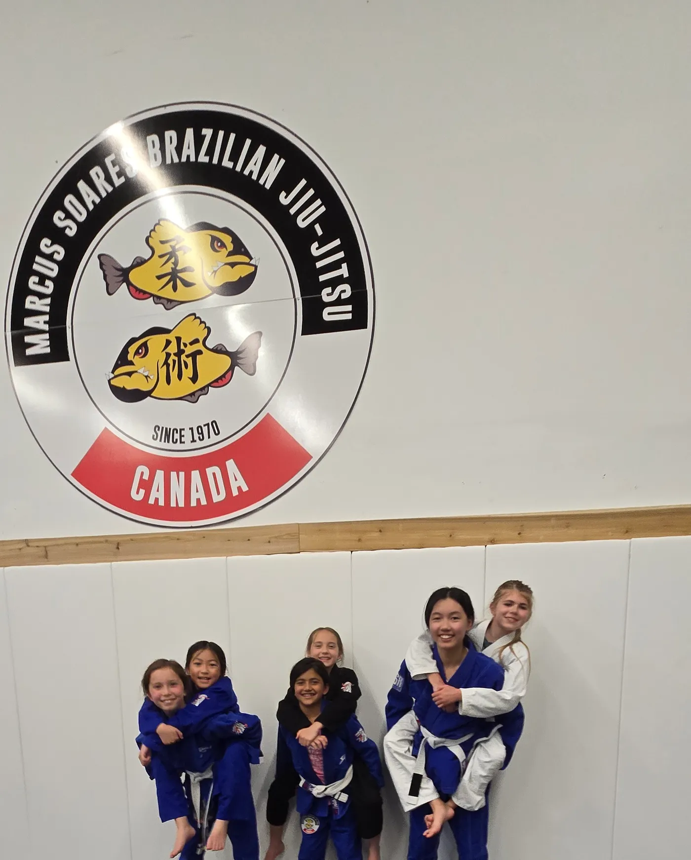 Kids class students under the academy crest at the Langley academy