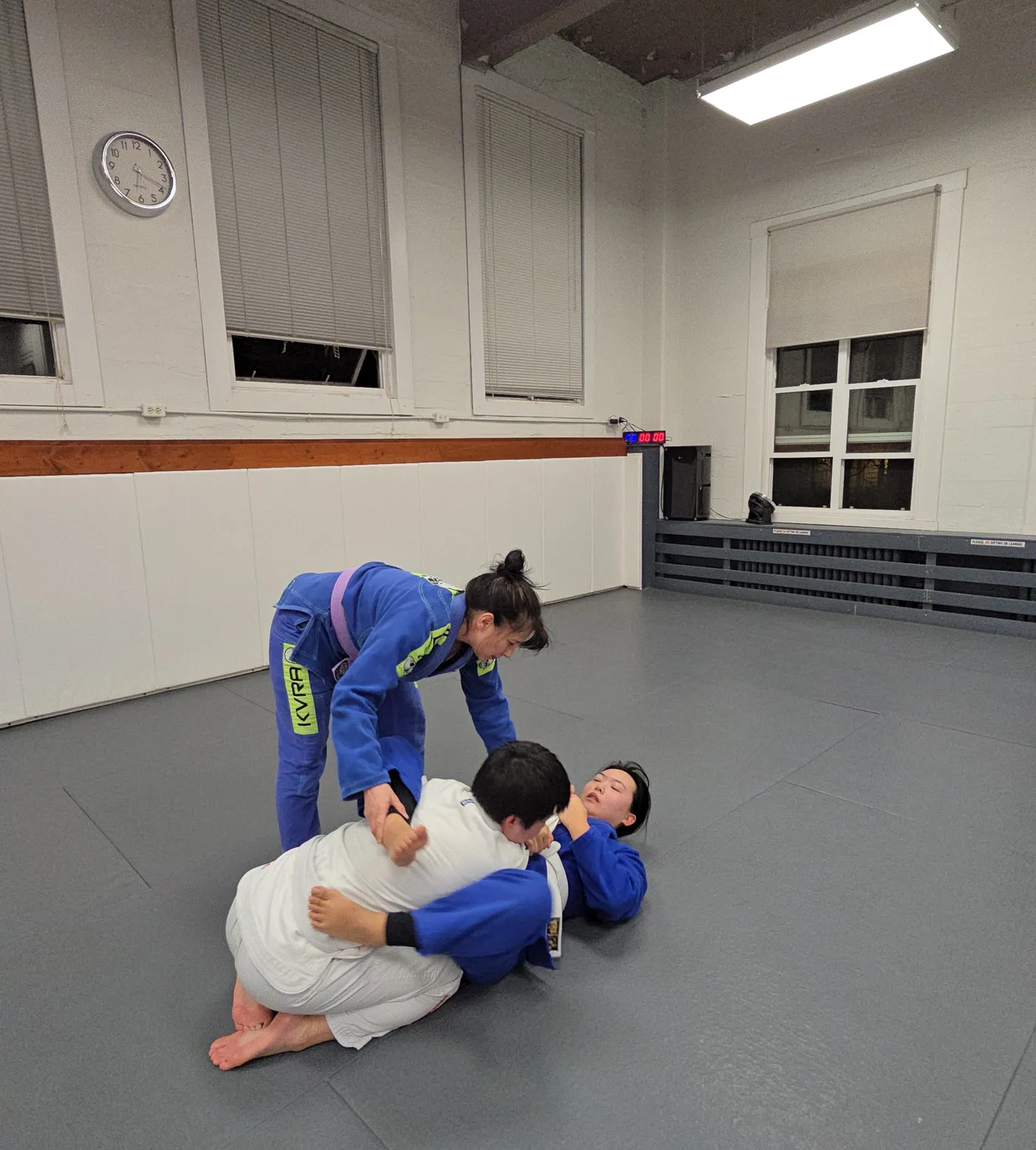 Three students training together on the mats at the Vancouver academy